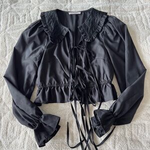 glamorous black top with tie detail and exaggerated collar